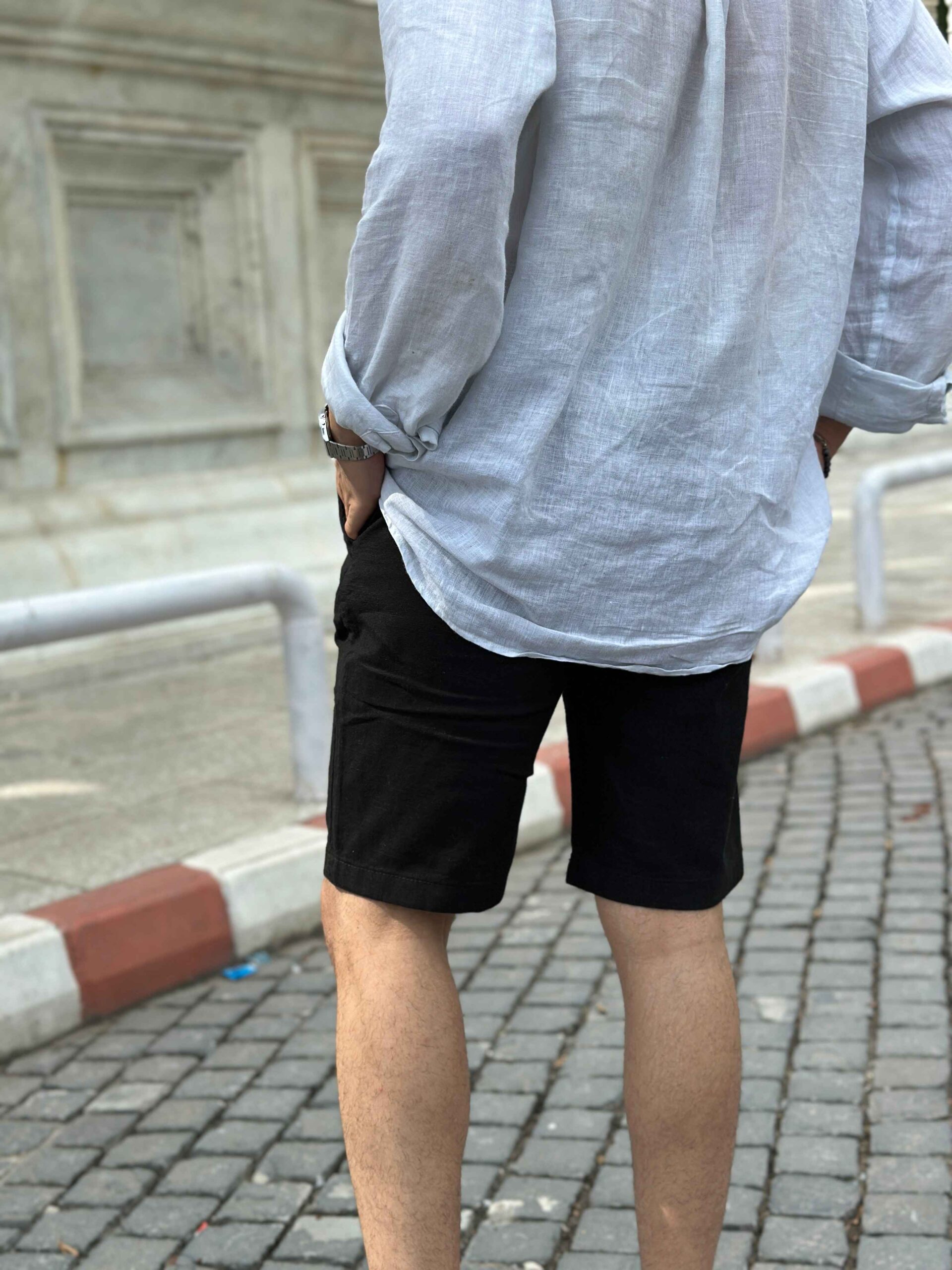 Back view of the black linen shorts, showing the pocket placement and relaxed fit.