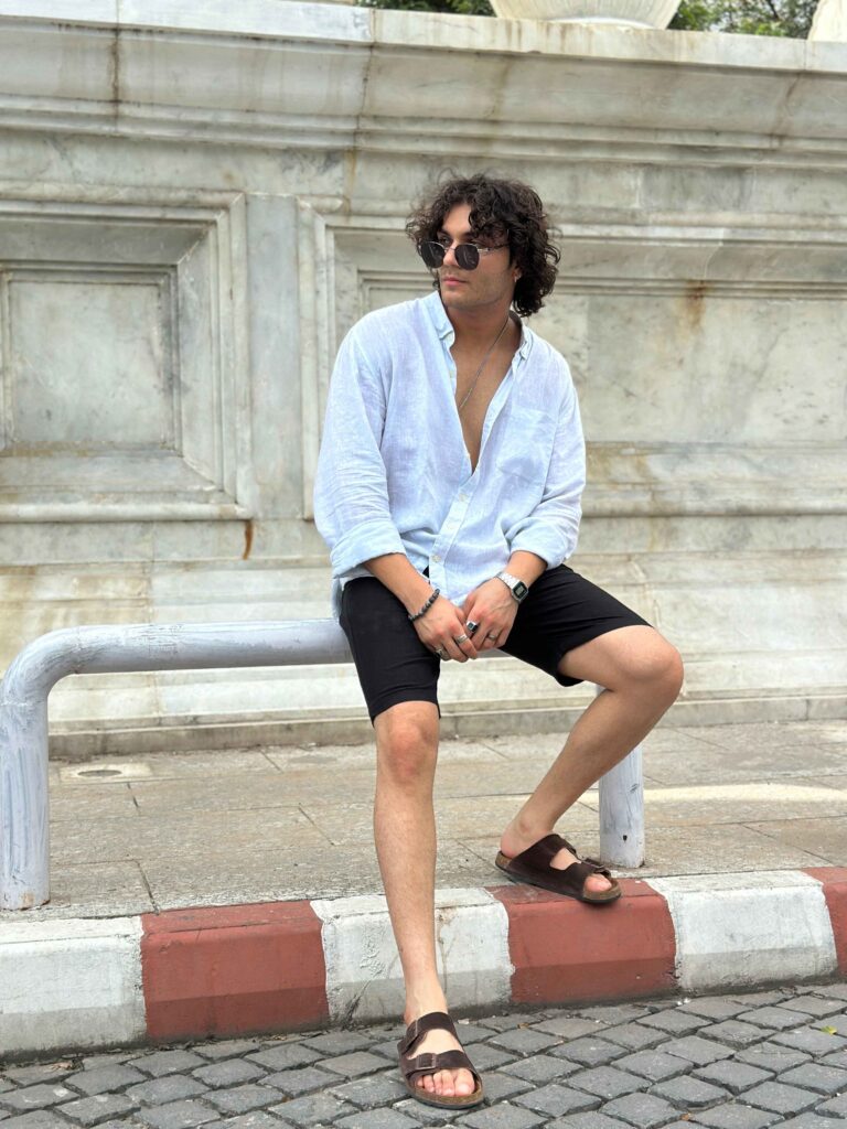 Man sitting in black linen shorts, demonstrating comfort and versatility for all-day wear.