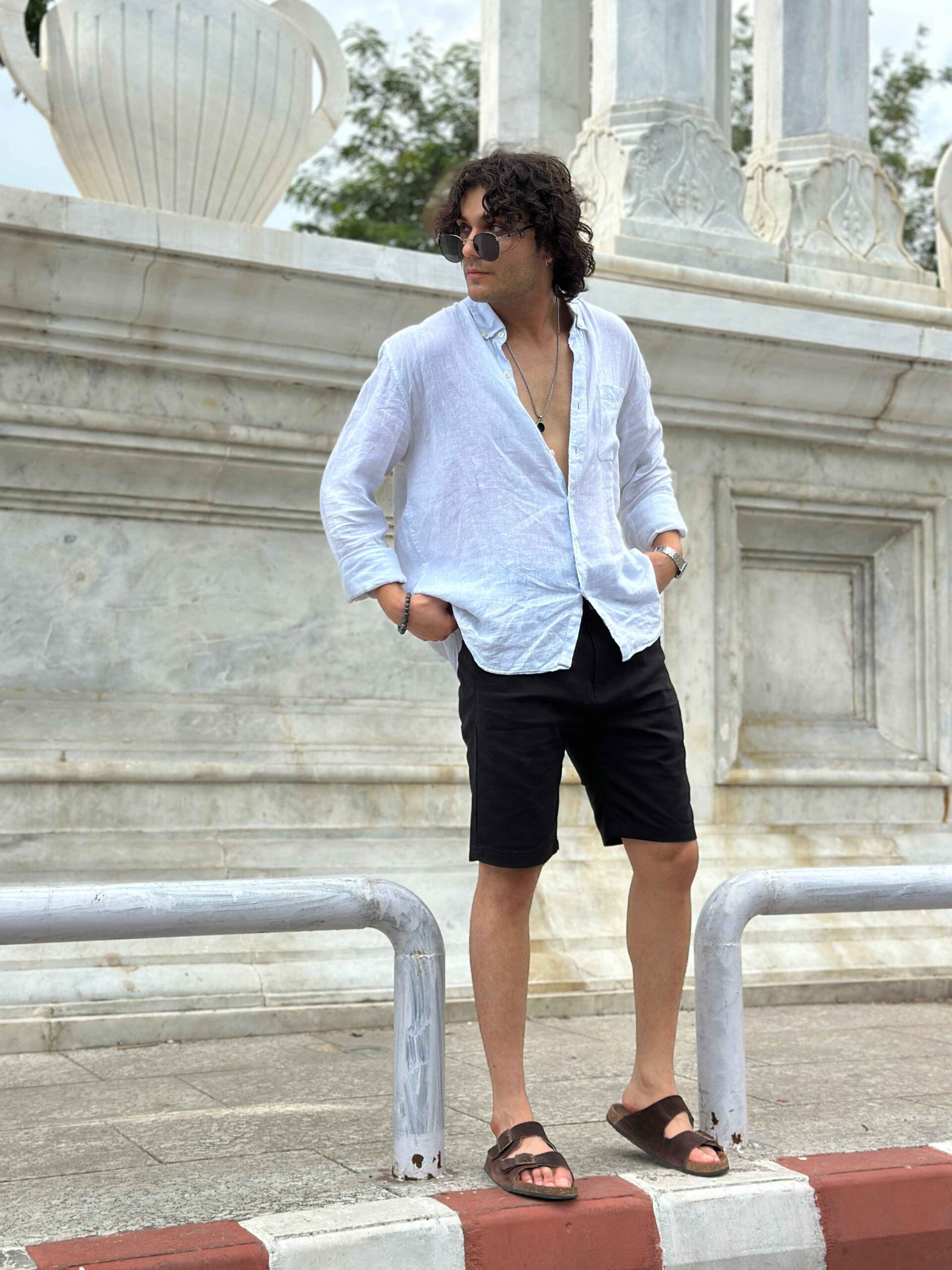 Men's black linen shorts paired with a white linen shirt for a classic, modern outfit.