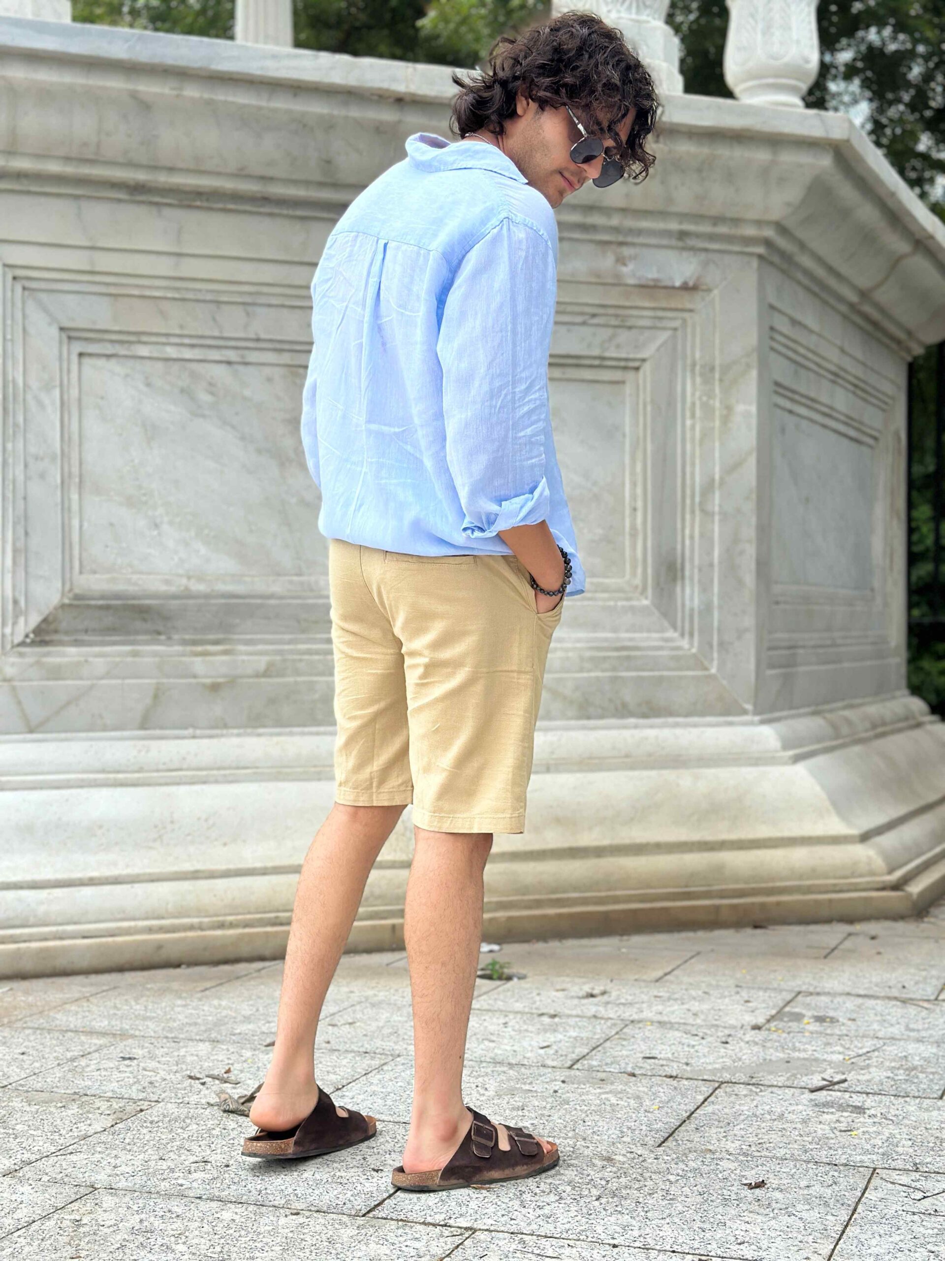 Side view of a man wearing cream linen shorts, highlighting the comfortable fit and style.